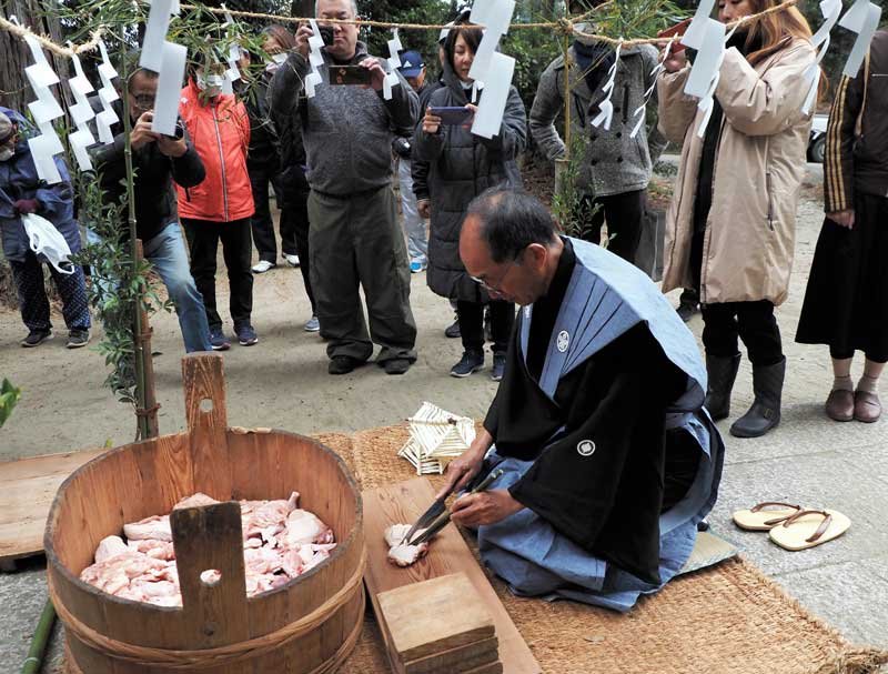 かみしも姿で肉を切り分ける神職「社家」の溝口さん＝５日、君津市