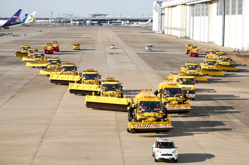 成田空港で積雪があったと想定し、Ｖ字型の編成を組んで除雪の訓練走行を行う特殊車両＝１３日、成田市