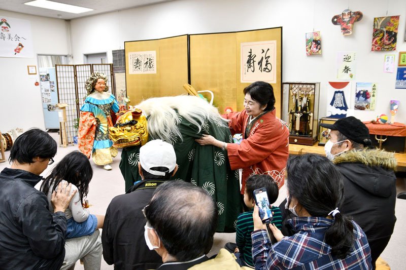 獅子が来場者らの頭をかむしぐさをして回った＝香取市