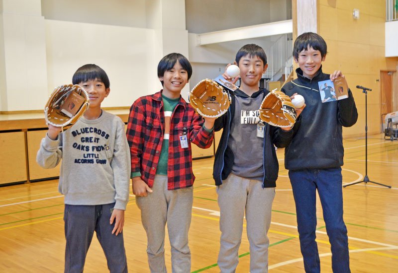 大谷選手から贈られたグローブを受け取り笑顔を見せる児童＝１２日、市立船橋小学校
