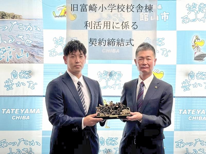 契約締結式でキクラゲを掲げる長谷部社長（左）と森市長＝館山市役所
