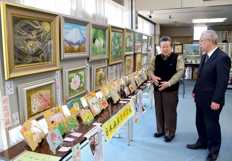 作品を披露する矢部宏さん（左）と房総信用組合の三谷徹理事長＝茂原市