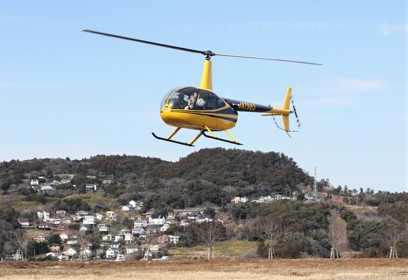 利用客を乗せ、城西国際大学安房キャンパス跡地に着陸するヘリコプター＝鴨川市
