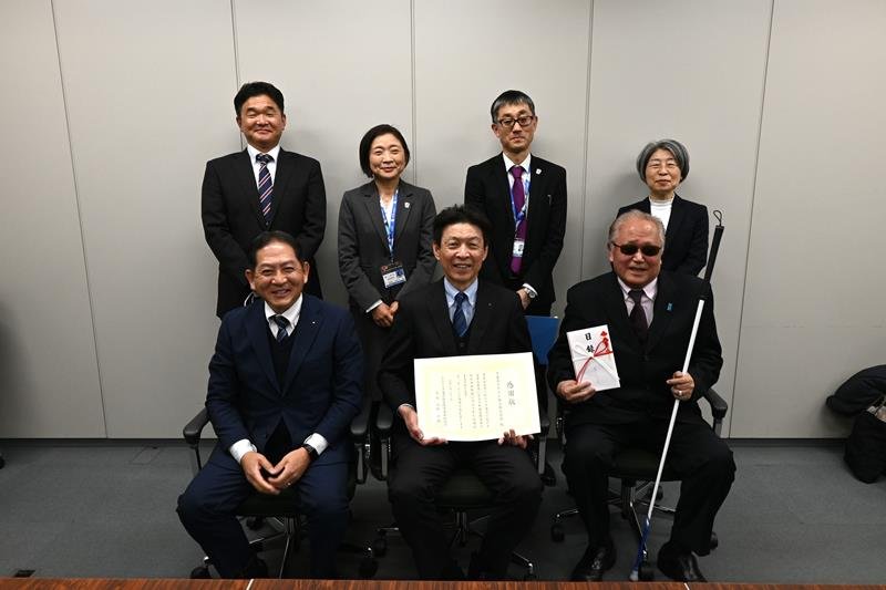 目録を手にする今野会長（前列右）と、廣瀬取締役（同中央）ら＝県庁

