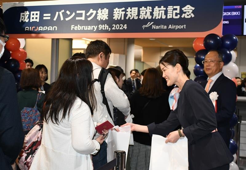 成田空港からバンコクに向かうエアージャパン就航便の搭乗ゲートを通過する旅客ら＝２月９日、成田市

