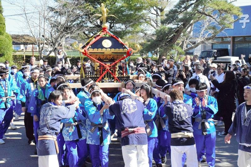 １、２年生や保護者が出迎える中、みこしを担ぎ白子中に到着した３年生＝３月３日、白子町
