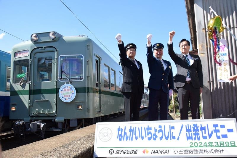 ホームに入った新車両と気勢を上げる竹本社長（左）ら＝９日、銚子電鉄仲ノ町駅
