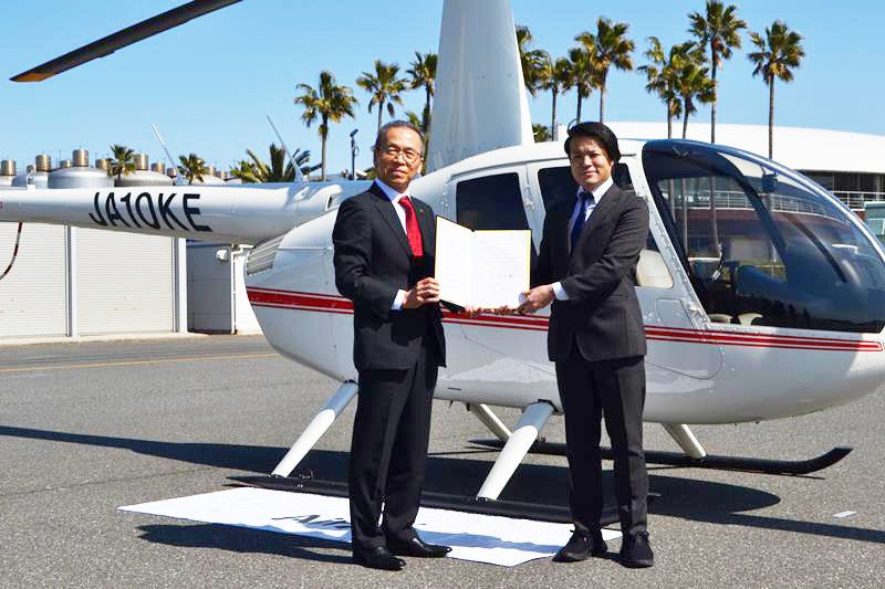 ヘリの前で、救援物資空輸協定を結んだ手塚社長（右）と松戸市長＝１１日、船橋市