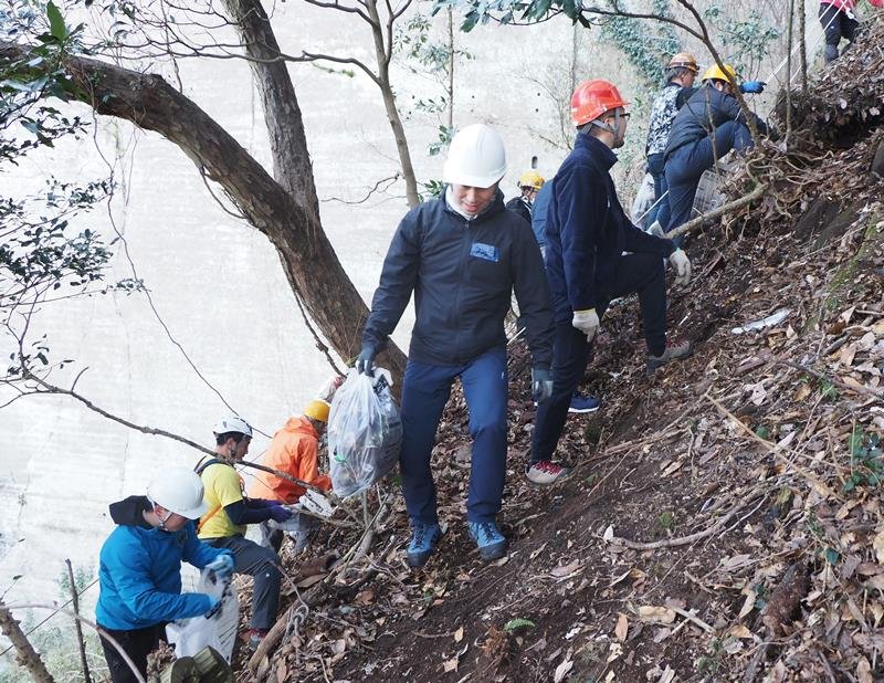 山の斜面に散乱したごみの除去作業に取り組むボランティア＝富津市

