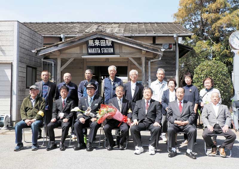 長年担ってきた窓口業務の終了を迎え、馬来田駅前で記念撮影する住民ら＝３１日、木更津市