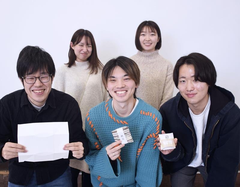 納豆向け折り畳み紙パック容器をデザインした、千葉大工学部の小松野幹さん（中央）、野畠歌乃さん（奥右）ら＝２月、千葉市（共同）
