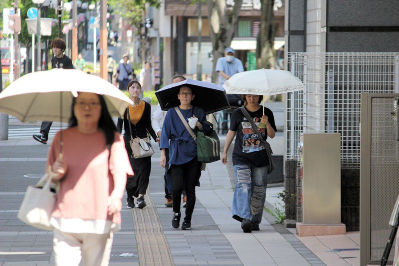 千葉市中央区で日傘を差して歩く人たち＝５日
