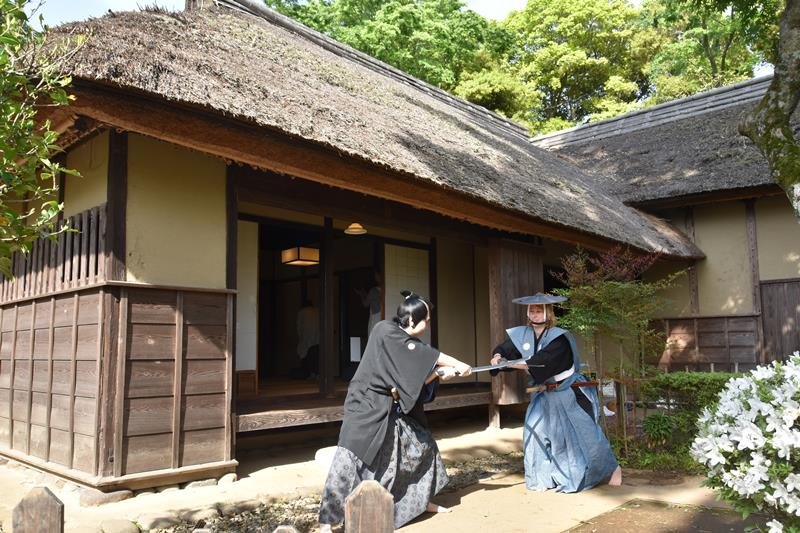 旧但馬家住宅で小松さん（手前）とともに各種体験をするドイツ人女性＝佐倉市宮小路町
