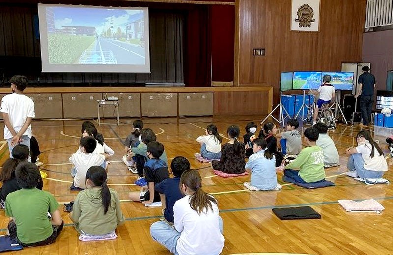 自転車シミュレーターの映像を見ながら、安全に通行する方法を学ぶ児童＝白井市