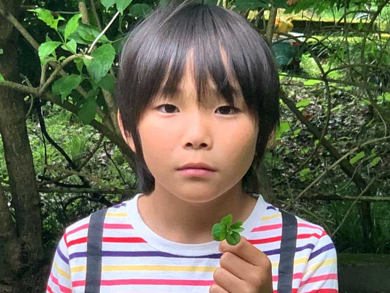 八つ葉のクローバーを見つけた菊池陽輝さん＝いすみ市（家族提供）
