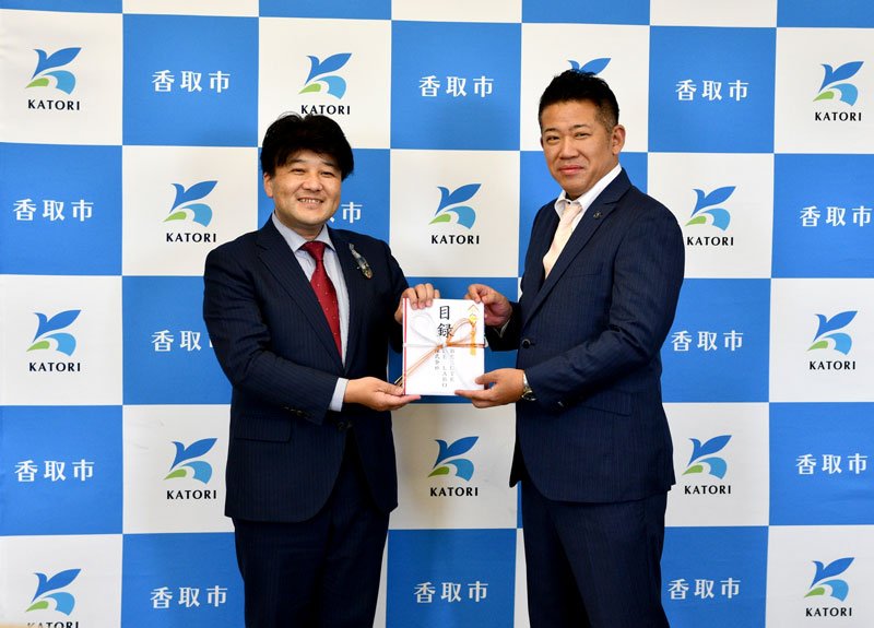 伊藤市長（左）に目録を手渡す渡辺社長＝香取市役所