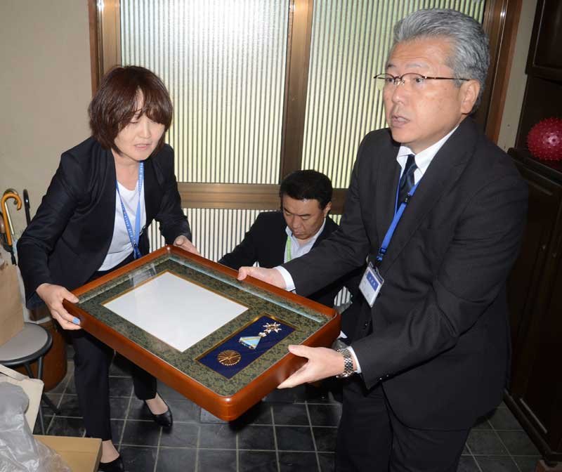遺族へ再調製した叙勲の「勲章」を渡しに訪れた山武市教委関係者ら＝２８日、同市