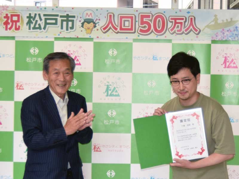 本郷谷市長から５０万人目の認定証を受け取った千葉さん＝７日、松戸市（市提供）