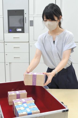 届いた新紙幣を取り出す千葉興業銀行の行員＝３日、千葉市美浜区

