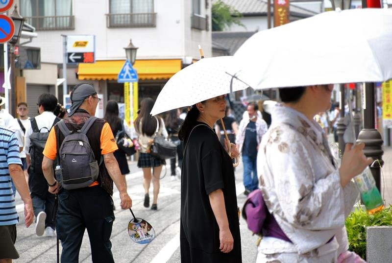 成田祇園祭が開幕した成田山新勝寺の参道では厳しい暑さの中、日傘を差したり、うちわを持ったりして歩く人が目立った＝５日午後、成田市