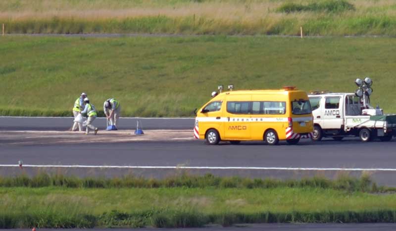 １３日未明に緊急着陸した貨物機が立ち往生し、朝までオイル拭き取りなど運用開始に向けた作業が続いた成田空港のＡ滑走路＝同日午前８時ごろ、成田市