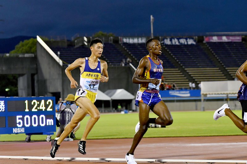男子５０００メートル決勝　競り合う八千代松陰の鈴木（左）＝博多の森陸上競技場