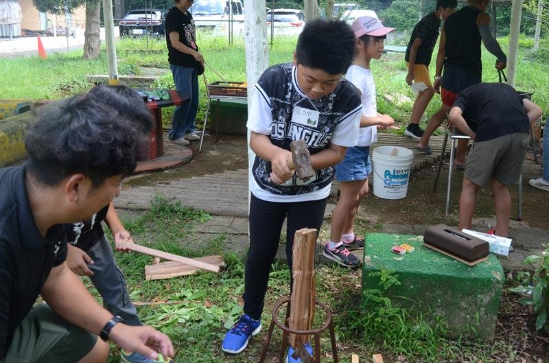 キャンプ場のスタッフにまきの割り方を教わりながら実践する児童＝横芝光町
