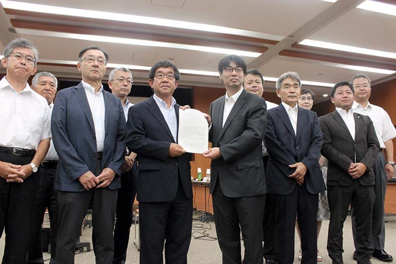検討委員会の第５回会合で答申書を受け取った越川市長（前列左から３人目）と、検討委の委員＝２５日、銚子市保健福祉センター