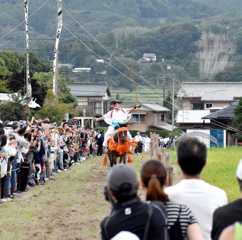 疾走する馬の上から的をめがけて矢を放つ禰宜＝２９日、鴨川市