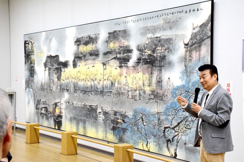 大作「人生楽事」を解説する王さん＝茂原市立美術館・郷土資料館