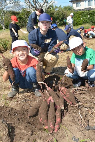 収穫したサツマイモを手に取る長者小の児童と大原高生＝いすみ市
