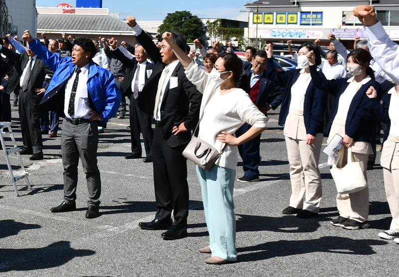 出発式で拳を突き上げる候補者の支援者ら＝１５日、香取市
