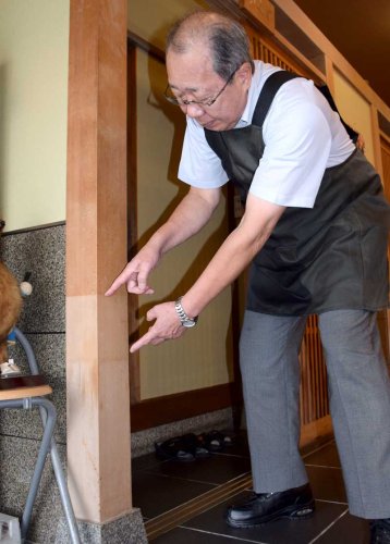 店内の柱に残る浸水跡を指で説明する新沢さん。上が５年前の房総豪雨で、下が昨年９月の豪雨で浸水した高さ＝茂原市八千代
