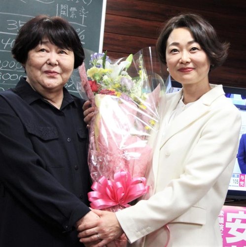 花束を受け取る立憲民主党の安藤氏（右）＝２７日、松戸市