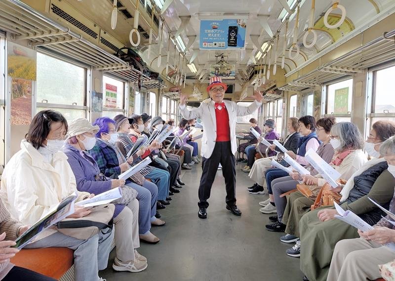 定期運行最後の歌声列車となった列車内で歌声を響かせる乗客ら＝２０日、市原市