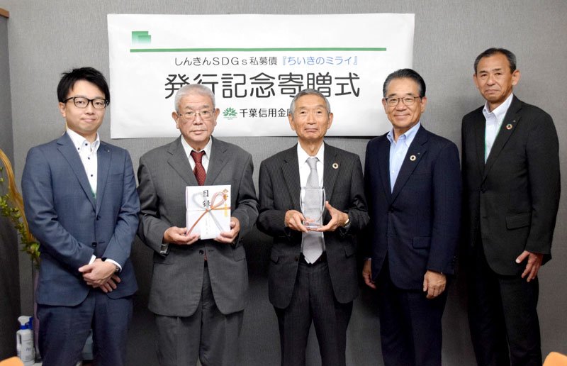 目録を持つ大越理事長（左から２人目）と小倉社長（同３人目）＝千葉市中央区
