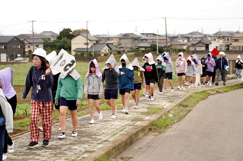 訓練で避難場所の高台を目指して歩く児童ら＝５日、銚子市