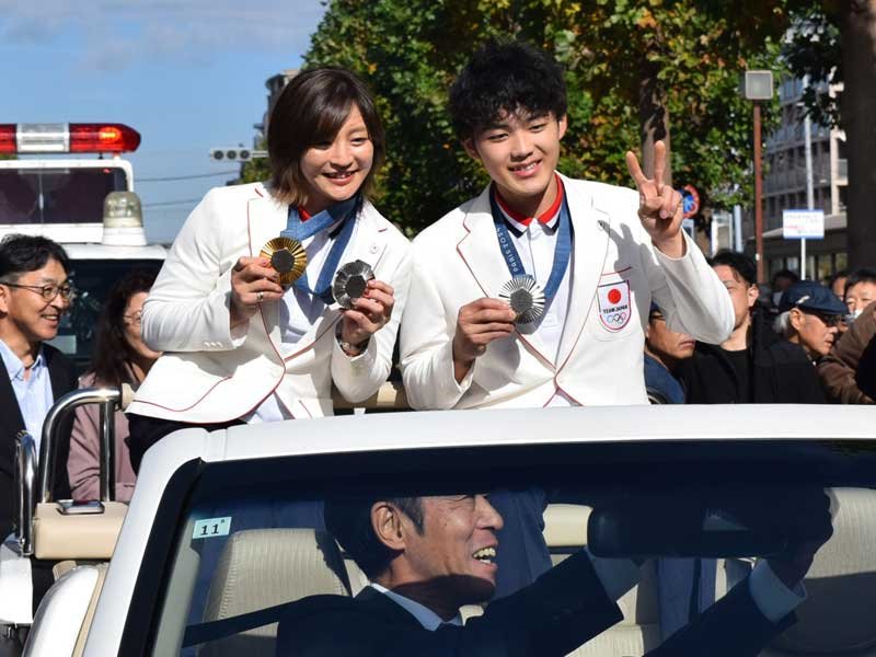 オープンカーの上で記念撮影する角田選手（左）と安楽選手＝９日、八千代市