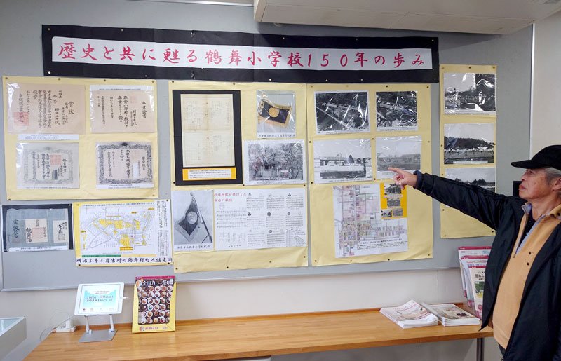 鶴舞小学校に関する資料を説明する大岩さん＝市原鶴舞郵便局