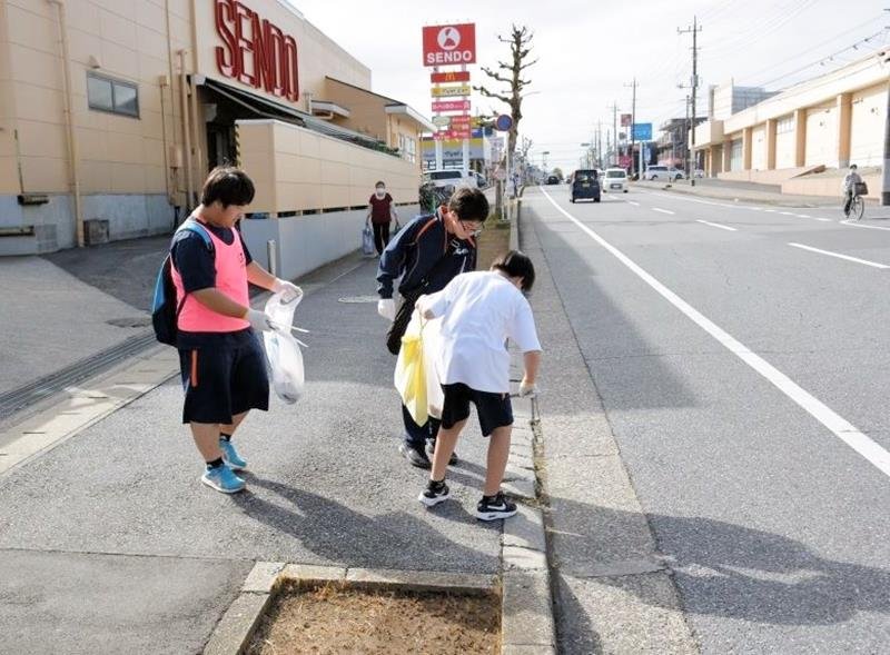 チームで競いながら道端でごみを拾い集める参加者＝市原市（市原市スポーツ協会提供）
