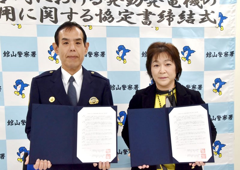 協定書を掲げる松本署長（左）と菊地社長＝館山署