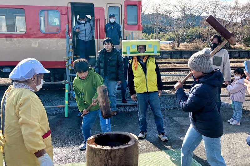 キハ２８の前で餅つきをする参加者ら＝２日、いすみ市