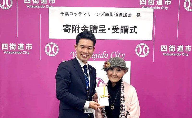 四街道市の鈴木陽介市長（左）に寄付金を贈った千葉ロッテマリーンズ四街道後援会の吉成会長（四街道市提供）