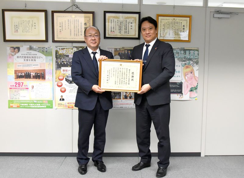 田中生活安全部長（左）から感謝状を受け取った星山理事長＝千葉市中央区