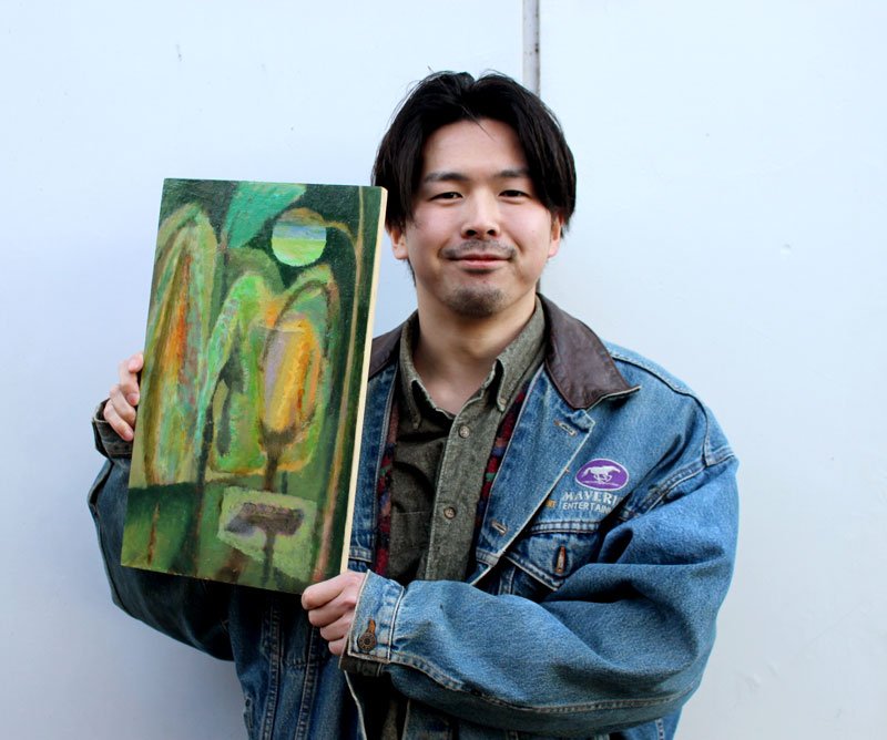 自作の絵を掲げる橋本さん＝１月３０日、我孫子市