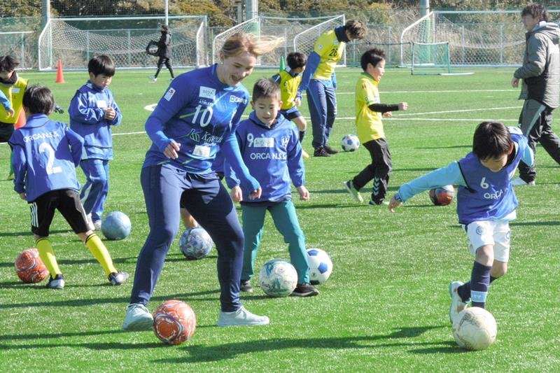 オルカ鴨川のアルマ・デービス選手（１０）とトレーニングする小学生ら＝２３日、勝浦市
