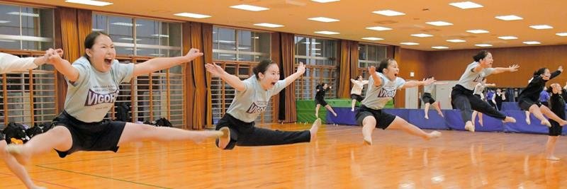 練習で高く足を上げるジャンプを見せる成田高校ダンスドリル部の部員たち＝成田市
