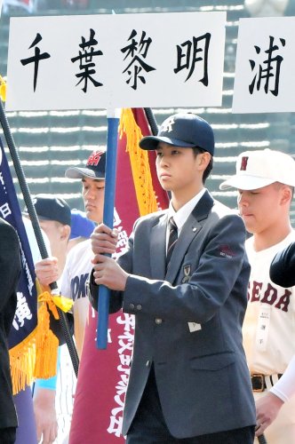 開会式で校名が書かれたプラカードを持つ千葉黎明の市丸（中央）＝甲子園