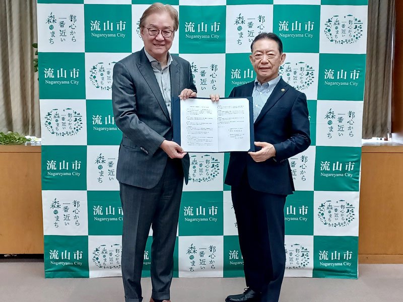 災害時の入浴支援などについての協定を締結した流山市の井崎義治市長（右）とオークランド観光開発の松永哲明副社長＝流山市（同市提供）