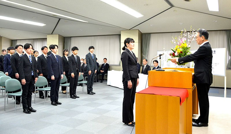 宮沢理事長から辞令を受け取る新人職員＝１日、千葉市中央区